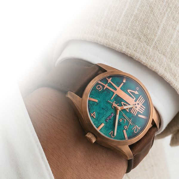 Reloj de cobre Grebe con dial turquesa en la muñeca